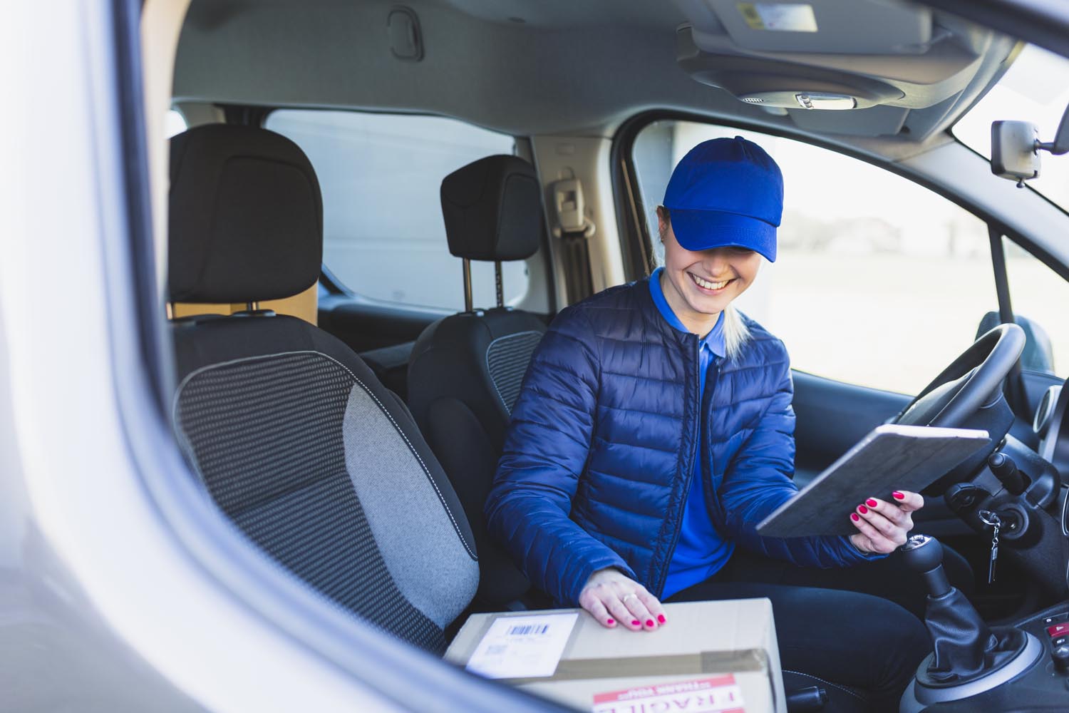 lieferungsmaedchen-mit-tablette-im-auto
